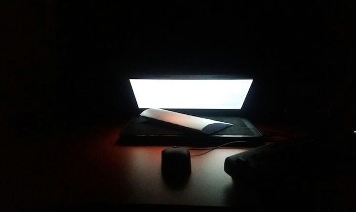 photo of turned on laptop computer on brown table